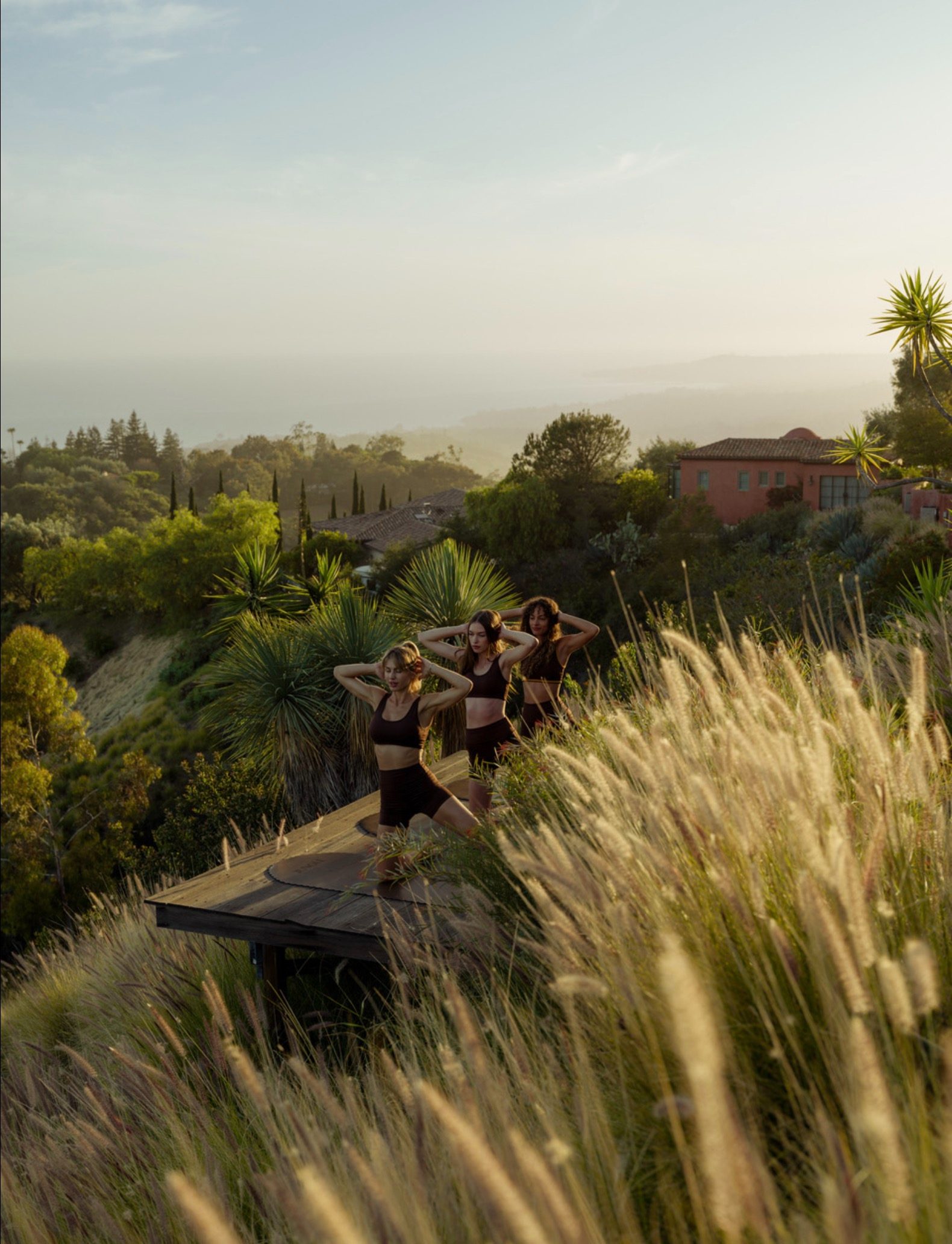 Three figures practicing on a hilltop deck